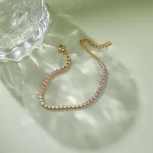Dettaglio del bracciale in acciaio inossidabile dorato con zirconi in rosa e viola.