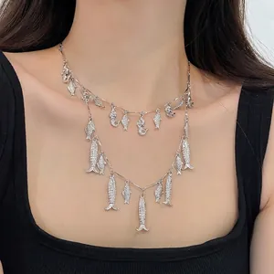 Collar doble capa plateado vintage con colgantes de pez de metal usado por una modelo femenina