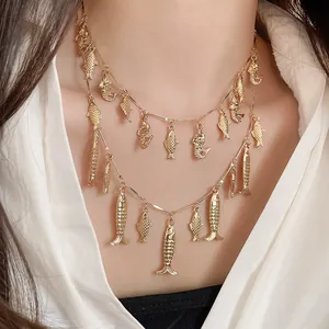 Primer plano detallado de un collar dorado de doble capa con dijes de peces retro