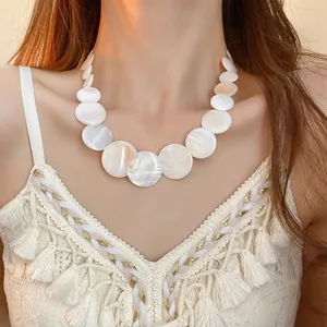 Close-up of an iridescent white shell circular choker necklace worn by a model