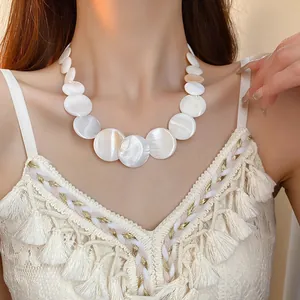 Close-up of elegant white shell round geometric choker on model for beach style