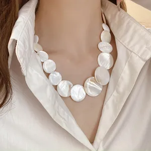 Elegant close-up detail of graduated iridescent white shell disc choker necklace on model