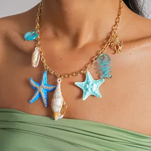 Vue détaillée d'un collier en chaîne dorée avec charms étoiles de mer et coquillages