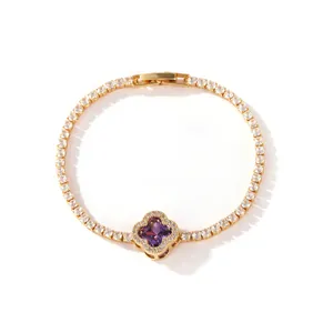 Close-up detail of a gold-plated tennis bracelet with a purple clover pendant and zircons