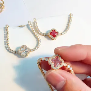 Detailed view of four-leaf clover bracelets with colored stones and gold plating