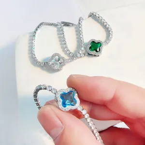 Detailed view of a silver clover bracelet featuring a blue gemstone and elegant tennis chain