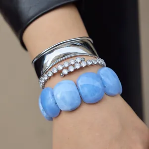 Detailed view of a chunky light blue marbled acrylic resin bracelet on a model wrist.