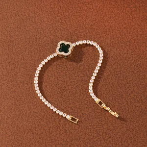 Detail showing the gold-plated tennis chain and green four-leaf clover centerpiece charm