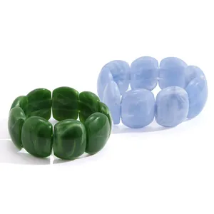 Two wide-face marbled acrylic resin bracelets in dark green and light blue colors