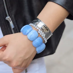 Close-up detail of a marbled blue acrylic resin bangle paired with silver bracelets.