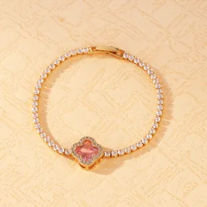 Close-up of elegant gold plated clover bracelet with sparkling pink stone and tennis chain details
