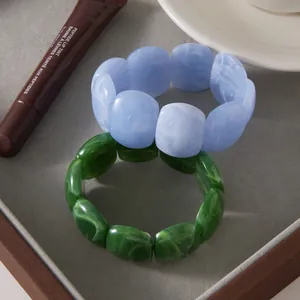 Detailed view of marbled blue and green acrylic resin bracelets in a stylish setting.