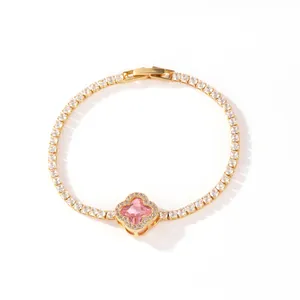 Detail of gold-plated tennis bracelet with elegant pink stone four-leaf clover pendant