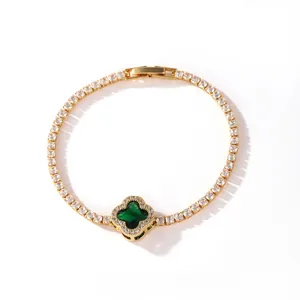 Close-up of gold-plated tennis bracelet with green four-leaf clover motif and clear zircons