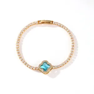 Close-up of gold plated tennis bracelet with sparkling blue clover flower charm detail