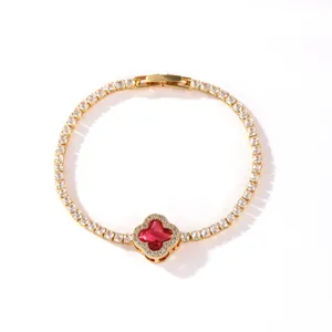 Detailed view of a gold-plated tennis bracelet with a red four-leaf clover motif