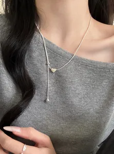 Primo piano dettagliato di una collana regolabile minimalista in argento con ciondolo a cuore