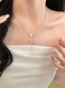 Vista dettagliata di una collana lariat a cuore in argento minimalista indossata al collo
