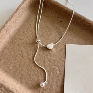 Vista dettagliata della collana a Y minimalista con cuore in argento e perla regolabile