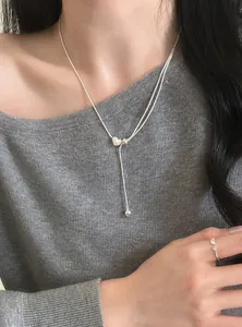 Vista dettagliata di una collana scorrevole a cuore in argento su una modella