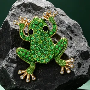 Nahaufnahme der grünen Strass-Froschbrosche auf natürlichem grauem Steinhintergrund