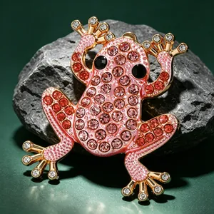 Makroaufnahme von Frosch-Ohrringen mit rosa Strasssteinen und kleinen weißen Kristallen