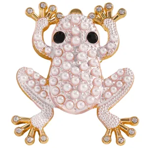 Detailansicht der Froschbrosche mit goldener Legierung, weißen Perlen und Steinchen