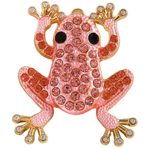 Detailaufnahme der goldenen Froschbrosche mit rosa Kristallen und schwarzen Edelsteinaugen