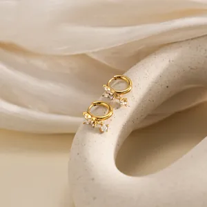 Élégantes boucles d'oreilles papillon plaquées or 18 carats avec pompons en zircon brillant.
