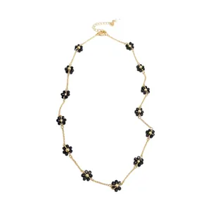 Elegant vintage gold chain necklace featuring black beaded flowers and adjustable extender