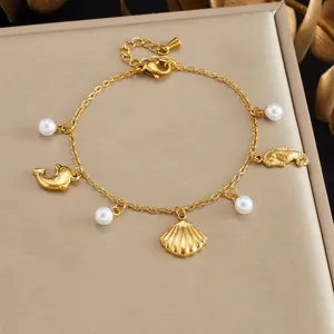 Detail shot of gold-plated ocean-themed bracelet with pearls and seahorse charms