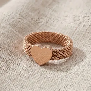 Detailed view of a rose gold mesh band ring featuring a smooth polished heart motif.
