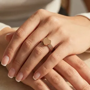 Close-up of rose gold minimalist heart ring with mesh woven band on hand