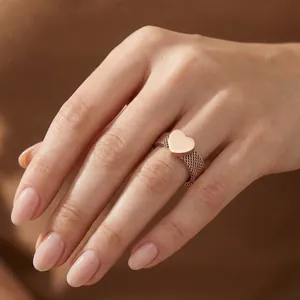 Detailed macro view of a rose gold mesh band ring with a polished heart centerpiece.