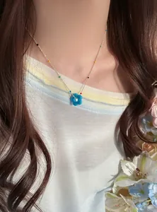 Detailaufnahme einer bunten Dopamin-Blumen-Perlenkette, die an einer Frau getragen wird.