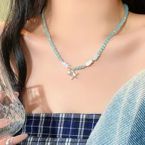 Detailed close-up of blue beaded necklace with fish elements and starfish pendant