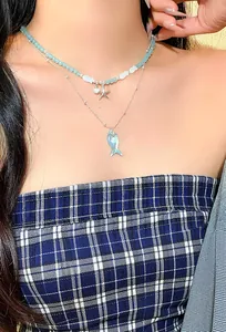 Close-up of ocean-themed double-layered necklace with blue beads and fish charms