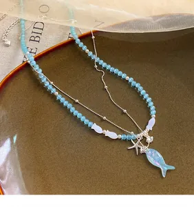 Macro view of blue beaded necklace featuring iridescent fish and starfish charms