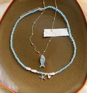 Detailed view of ocean-style blue beaded necklace featuring fish and starfish charms