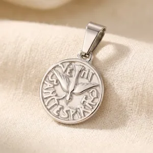 Detailed macro view of vintage round silver pendant with flying bird engraving and text