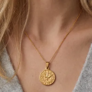 Close-up of vintage gold bird pendant necklace on a model