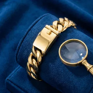 Macro shot of gold-plated Cuban link bracelet with rectangle box clasp on blue velvet