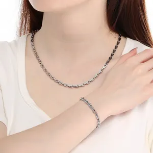 Dettaglio di un set collana e bracciale in acciaio inossidabile argento su modella