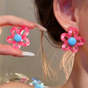 Detailed view of vibrant pink and blue flower earrings with a translucent petal finish.