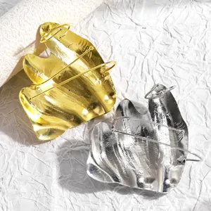 Detail view of artistic irregular folded knuckle rings in gold and silver finishes