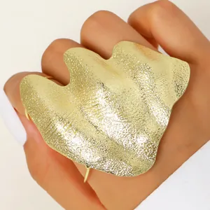 Macro detail of artistic irregular wrinkled gold ring with textured hammered surface