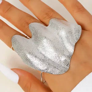 Detail shot of irregular wrinkled silver knuckle ring on hand, minimalist art design
