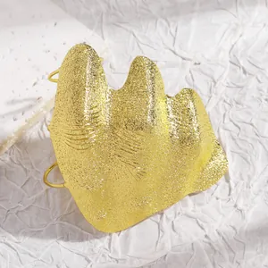 Detailed view of an artistic irregular gold pleated knuckle ring with textured finish.