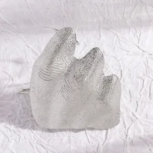 Detailed macro view of an artistic irregular folded silver texture knuckle ring.