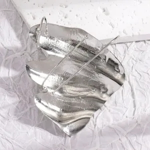Macro view showing the artistic irregular pleated silver finish on a unique joint ring design